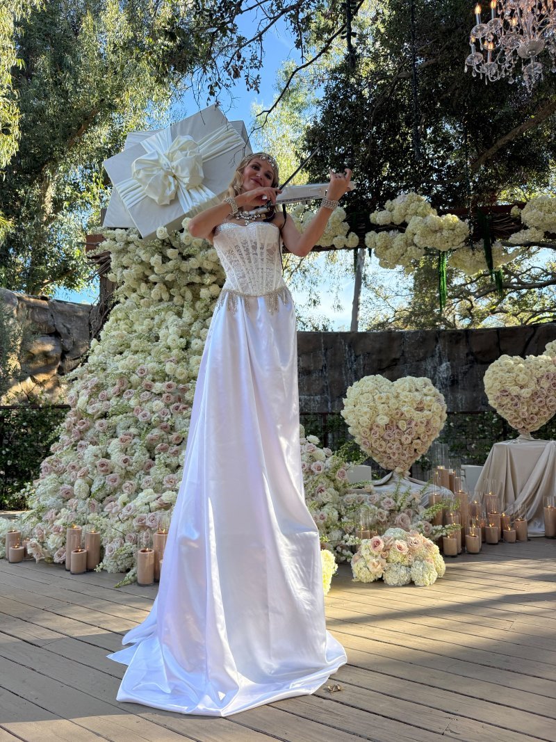 Live violin in front of a white floral wall